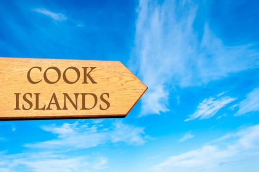Wooden arrow sign pointing destination COOK ISLANDS against clear blue sky with copy space available. Travel destination conceptual image