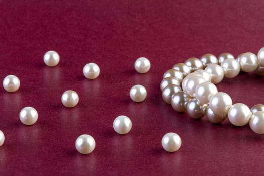 Silver and White pearls necklace on dark red background