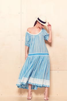 Full-length portrait of a lovely woman in romantic dress on wodden background