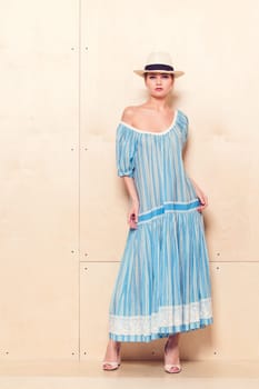Full-length portrait of a lovely woman in romantic dress on wodden background