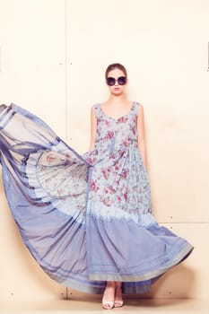 Full-length portrait of a lovely woman in romantic dress on wodden background