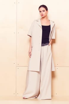 Full height portrait of a young woman in a bright pantsuit