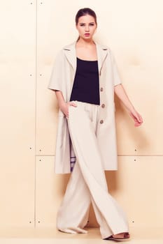 Full height portrait of a young woman in a bright pantsuit
