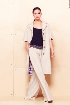 Full height portrait of a young woman in a bright pantsuit