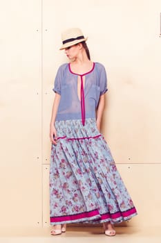 Full-length portrait of a lovely woman in romantic dress on wodden background