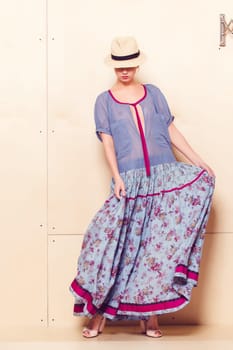 Full-length portrait of a lovely woman in romantic dress on wodden background