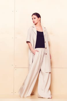 Full height portrait of a young woman in a bright pantsuit