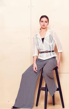 Full height portrait of a young woman in a bright pantsuit