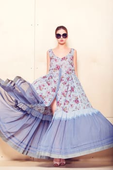 Full-length portrait of a lovely woman in romantic dress on wodden background
