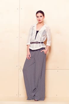 Full height portrait of a young woman in a bright pantsuit