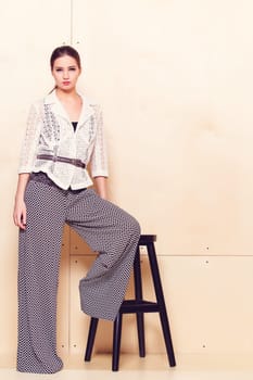 Full height portrait of a young woman in a bright pantsuit
