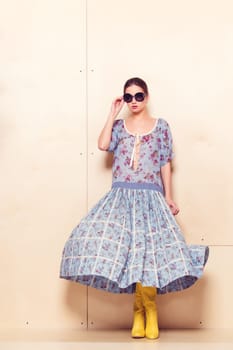 Full-length portrait of a lovely woman in romantic dress on wodden background