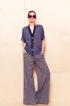 Full height portrait of a young woman in a bright pantsuit