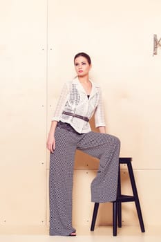Full height portrait of a young woman in a bright pantsuit