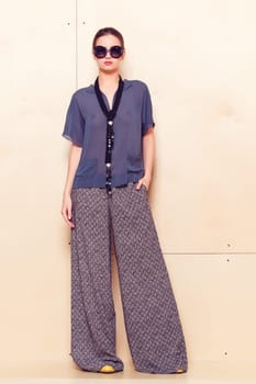 Full height portrait of a young woman in a bright pantsuit