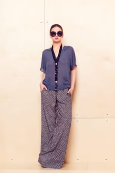 Full height portrait of a young woman in a bright pantsuit