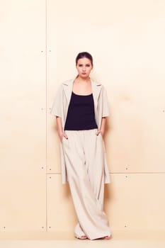 Full height portrait of a young woman in a bright pantsuit