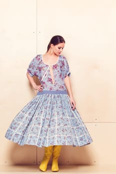 Full-length portrait of a lovely woman in romantic dress on wodden background