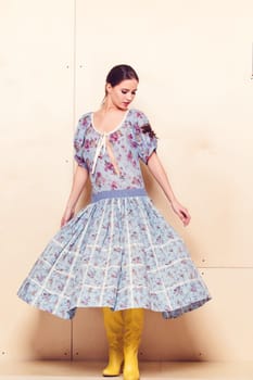 Full-length portrait of a lovely woman in romantic dress on wodden background
