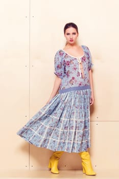 Full-length portrait of a lovely woman in romantic dress on wodden background