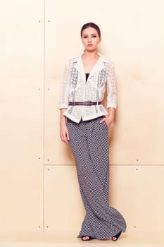 Full height portrait of a young woman in a bright pantsuit