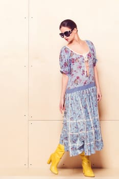 Full-length portrait of a lovely woman in romantic dress on wodden background