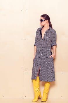 Full-length portrait of a lovely woman in romantic dress on wodden background