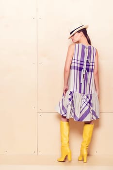 Full-length portrait of a lovely woman in romantic dress on wodden background