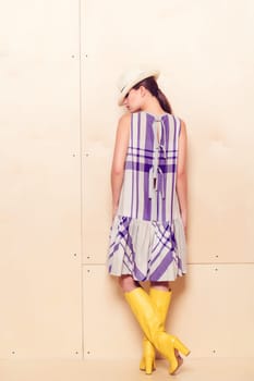 Full-length portrait of a lovely woman in romantic dress on wodden background