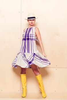 Full-length portrait of a lovely woman in romantic dress on wodden background