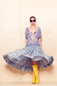 Full-length portrait of a lovely woman in romantic dress on wodden background