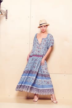 Full-length portrait of a lovely woman in romantic dress on wodden background