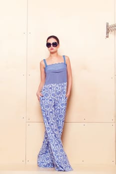 Full height portrait of a young woman in a bright pantsuit