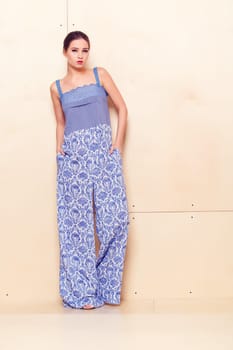 Full height portrait of a young woman in a bright pantsuit