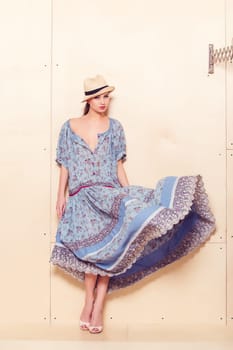 Full body slim woman in blue sundress on wooden background