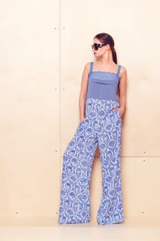 Full height portrait of a young woman in a bright pantsuit