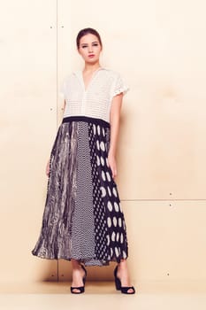 Full-length portrait of a lovely woman in romantic dress on wodden background