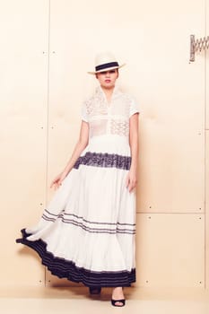Full-length portrait of a lovely woman in romantic dress on wodden background