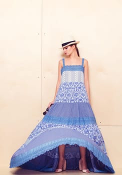 Full-length portrait of a lovely woman in romantic dress on wodden background