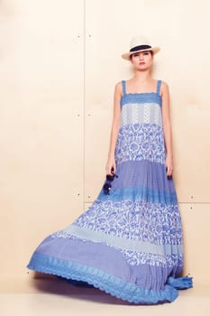 Full-length portrait of a lovely woman in romantic dress on wodden background