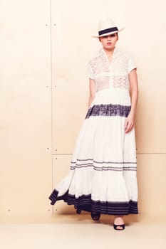 Full-length portrait of a lovely woman in romantic dress on wodden background