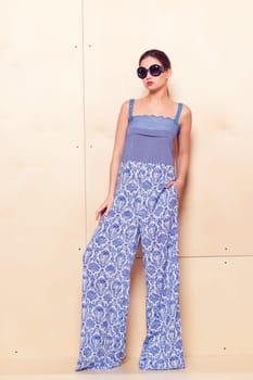 Full height portrait of a young woman in a bright pantsuit