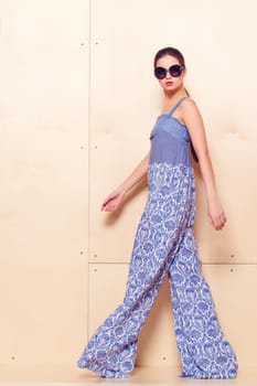 Full height portrait of a young woman in a bright pantsuit