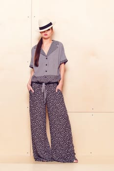 Full height portrait of a young woman in a bright pantsuit