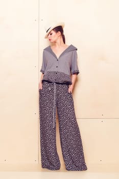 Full height portrait of a young woman in a bright pantsuit