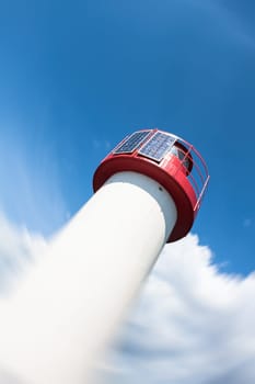 Lighthouse Photovoltaic Sky . Sea Mark at the harbor with blue sky with clouds in background