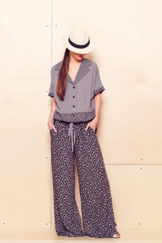 Full height portrait of a young woman in a bright pantsuit