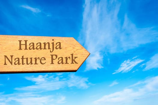 Wooden arrow sign pointing destination TALLINN, ESTONIA against clear blue sky with copy space available. Travel destination conceptual image
