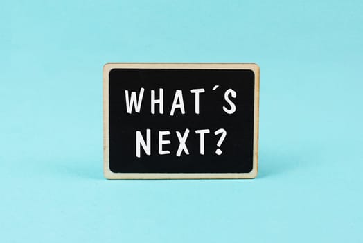 The phrase what´s next is standing on a chalkboard, having new goals and strategies, making plans for future