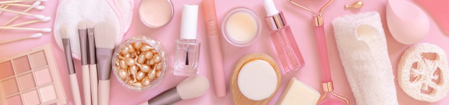 Skin care and makeup products on light pink, top view, banner. Flat lay with natural beauty products and decorative cosmetics. Everyday woman face care routine. Pastel composition